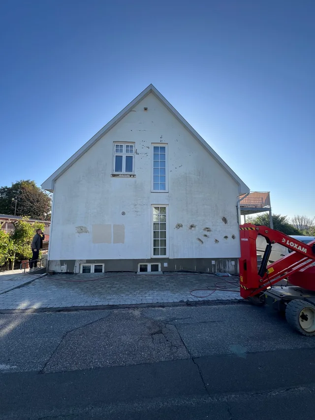 Husets gavlfacade før arbejdet med afskallet maling og synlige prøvefelter
