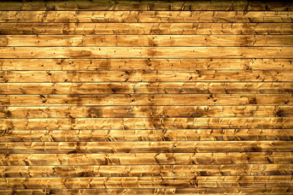Textured wooden planks forming a rustic wall, perfect for backgrounds or design elements.
